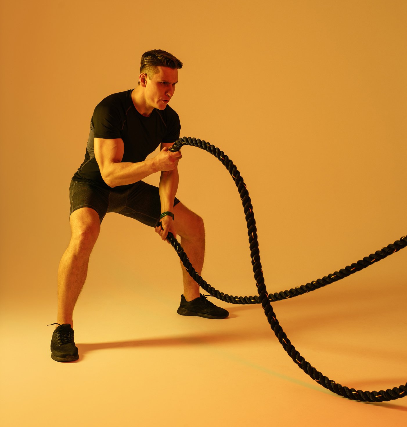 Athletic man with fit muscular body training in studio